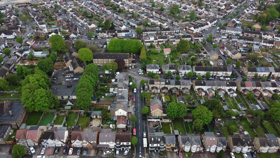 Aerial view of a residential neighbourhood in Brentford, showing a straight street lined with terraced houses and semi-detached homes, with parked cars on both sides. The area features densely packed 